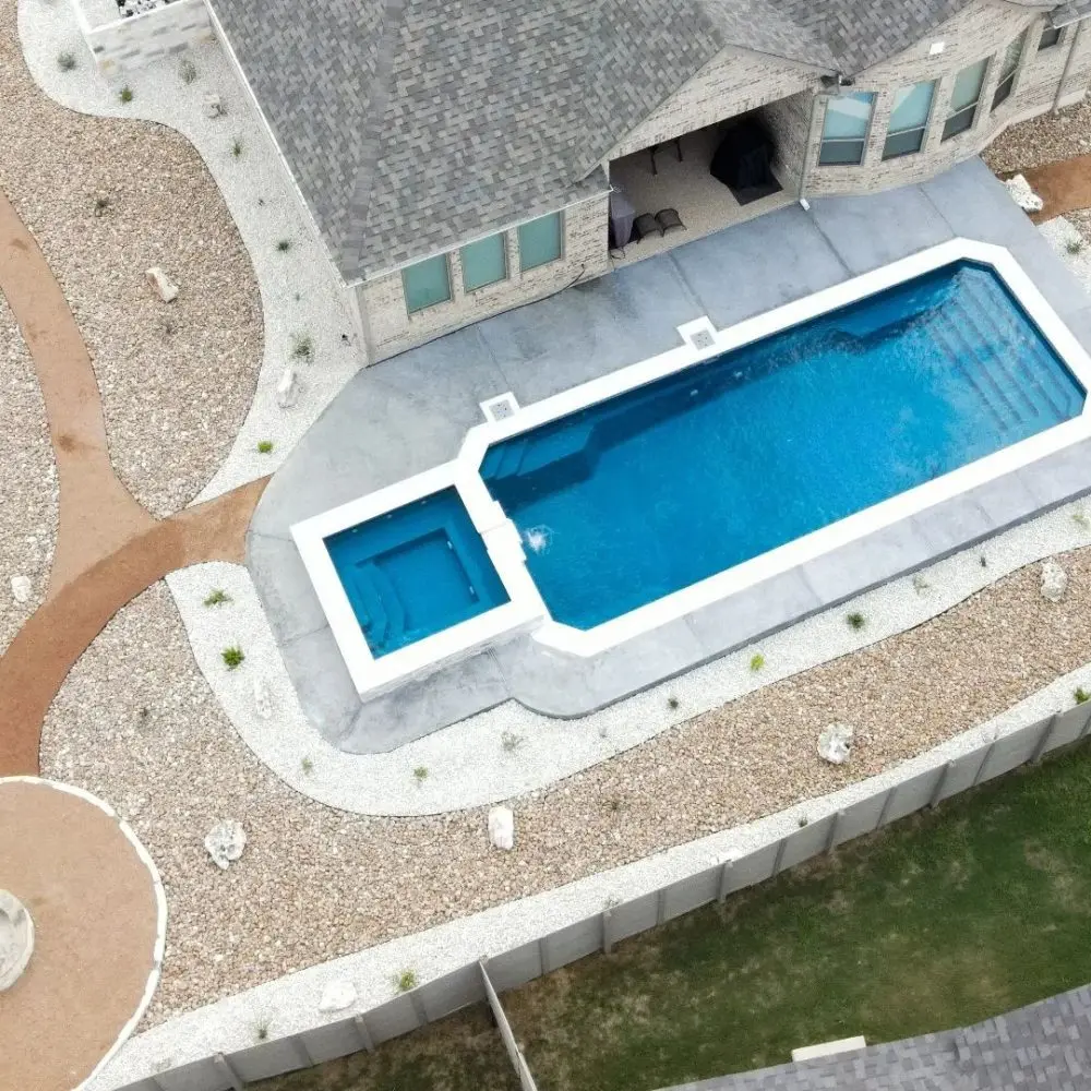 Grande fiberglass pool with cube spa at dusk in upstate New York